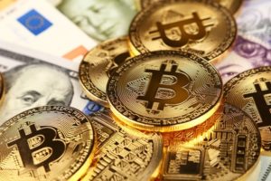 Bitcoins sitting atop paper money