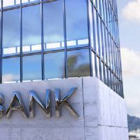 Composite image of bank building against city with harbour
