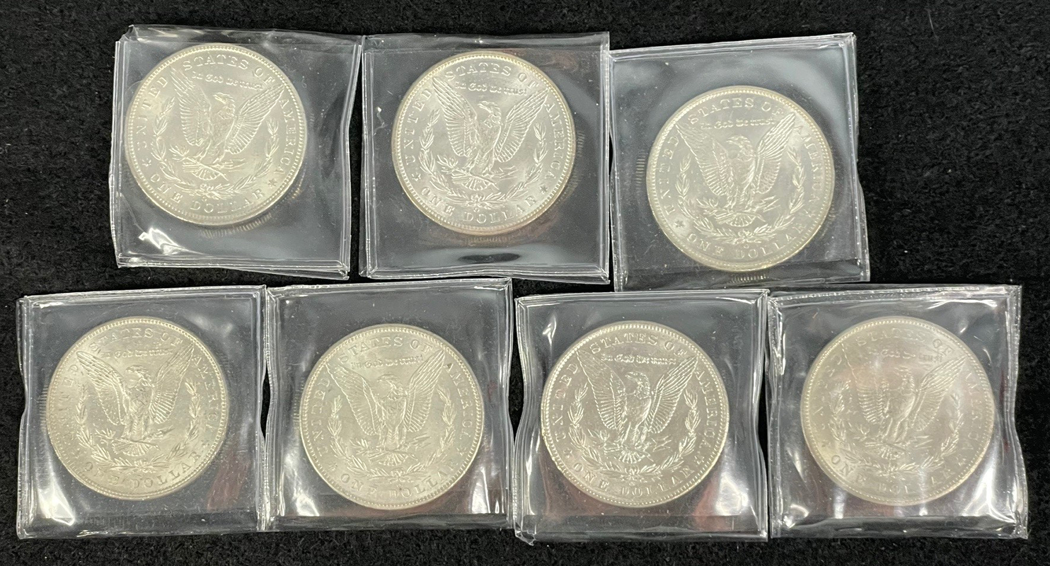 7-piece morgan dollar set in BU condition, reverse. Coins are in plastic sleeves