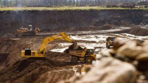 Open-pit platinum mine showing excavators and haul trucks extracting platinum-bearing ore in Russian mining operation 