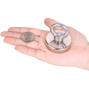 Quarter-ounce silver round in palm beside powerful neodymium fishing magnet showing relative scale of fractional bullion piece.