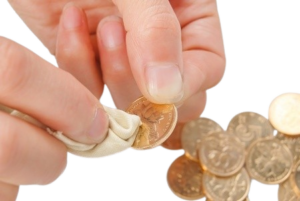 Hands cleaning a coin with a cloth.
